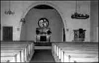 So bietet sich der Kirchen-Innenraum seit dem Neubau dem Besucher (links vor dem Bogenrand der Taufengel, die Kanzel befindet sich rechts).