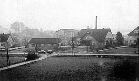 Möbelfabrik Pecher in den 1960er-Jahren, parallel zur quer durch das Bild verlaufenden Herforder Straße ist der Lagerschuppen für das Holz zu sehen. Nach links unten verläft der Zugang zur Siedlung Auf dem Pulsfeld